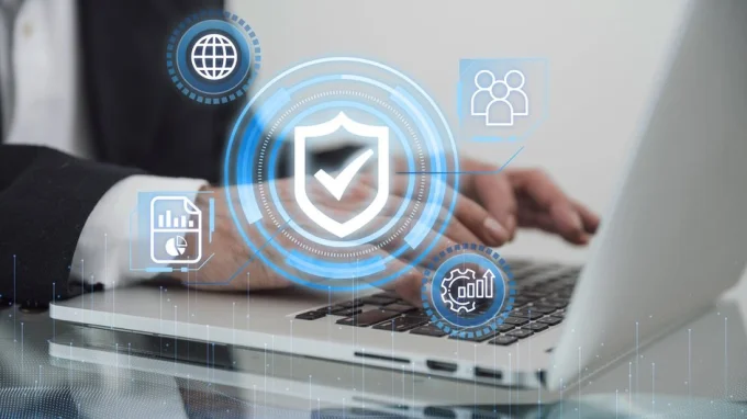 Мужчина работает за ноутбуком с иконкой антивируса