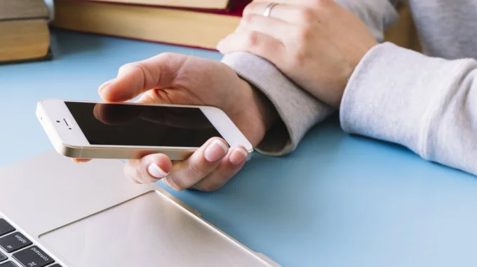 Девушка перезагружает телефон, потому что не отправляются СМС