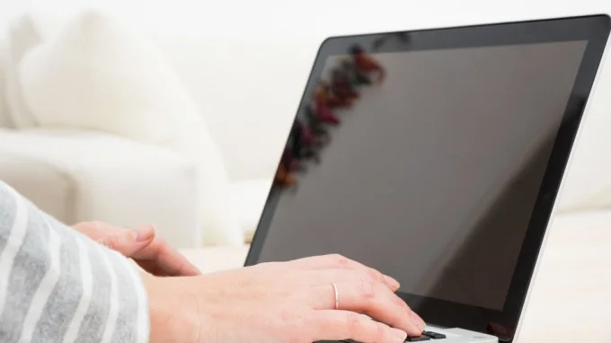 На крупном плане руки лежат на клавиатуре ноутбука