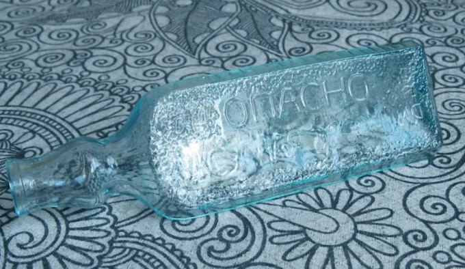 бутылка лежит на столе